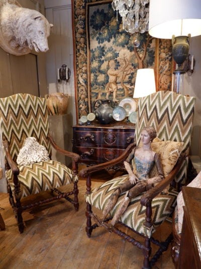 Paire de grands fauteuils en chêne sculpté bras à volutes et tissu flammé période Louis XIV