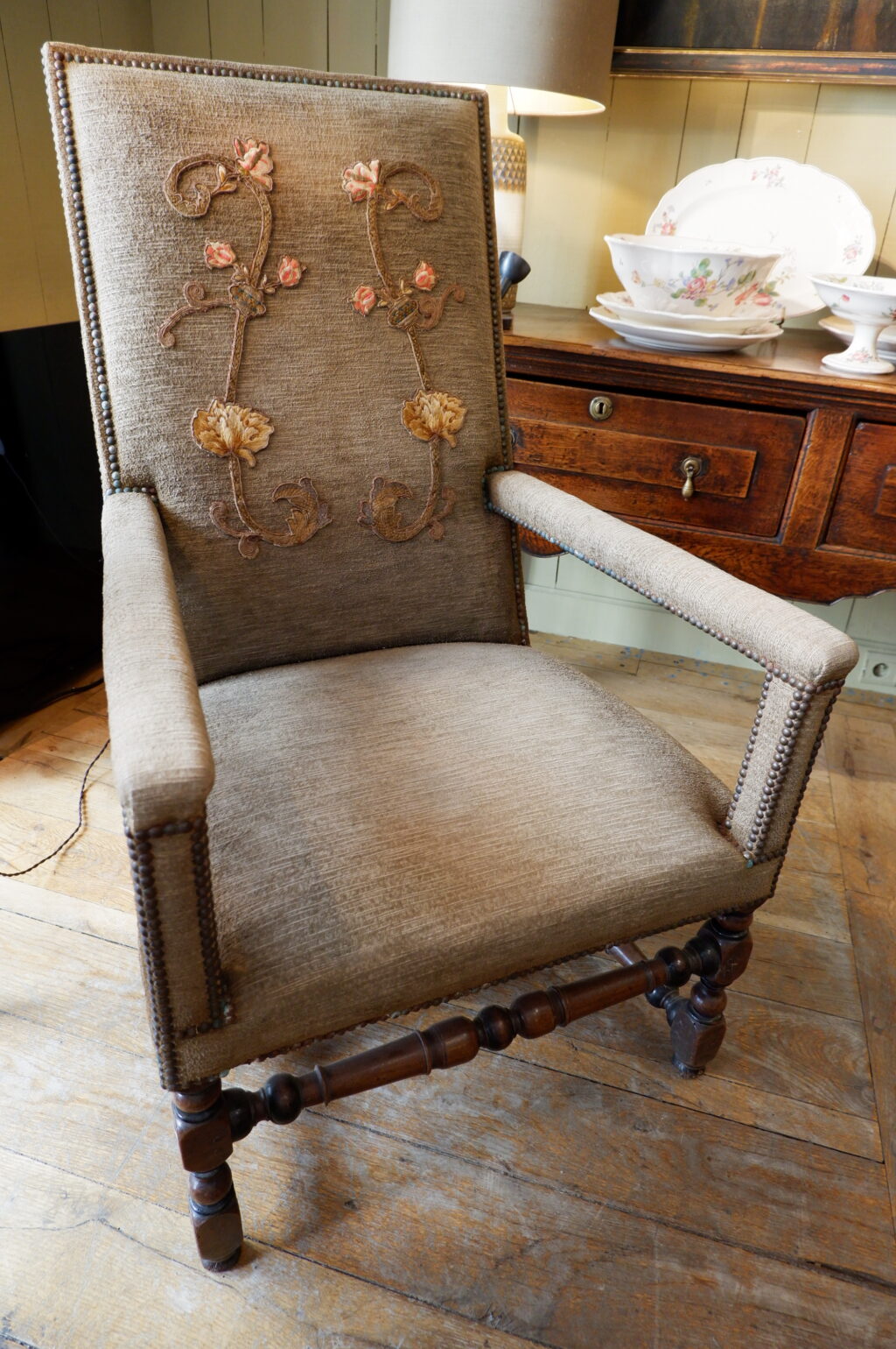Fauteuil Louis XIII en noyer sculpté et velours marron orné d'une applique brodée sur le dossier