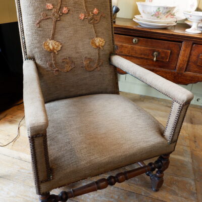 Louis XIII armchair in carved walnut and brown velvet adorned with an embroidered applique on the back.