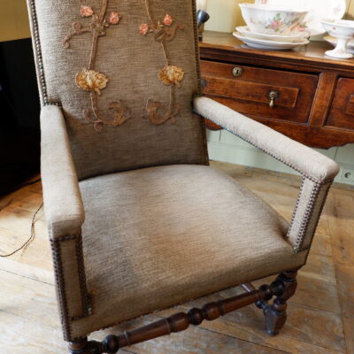 Fauteuil Louis XIII en noyer sculpté et velours marron orné d’une applique brodée sur le dossier