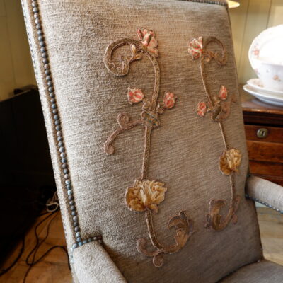 Fauteuil Louis XIII en noyer sculpté et velours marron orné d’une applique brodée sur le dossier