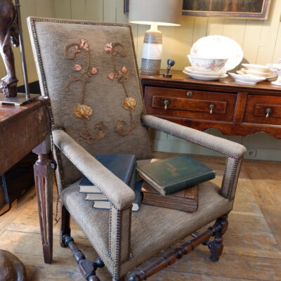 Fauteuil Louis XIII en noyer sculpté et velours marron orné d’une applique brodée sur le dossier