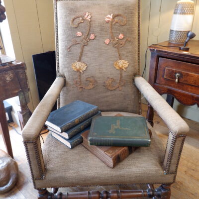 Fauteuil Louis XIII en noyer sculpté et velours marron orné d’une applique brodée sur le dossier