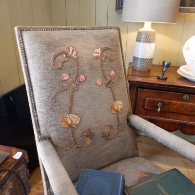Fauteuil Louis XIII en noyer sculpté et velours marron orné d’une applique brodée sur le dossier