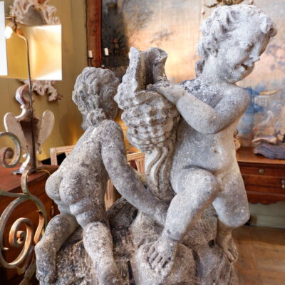 Centre de fontaine en pierre sculptée “deux putti tenant une corne d’abondance” sur socle en pierre – France