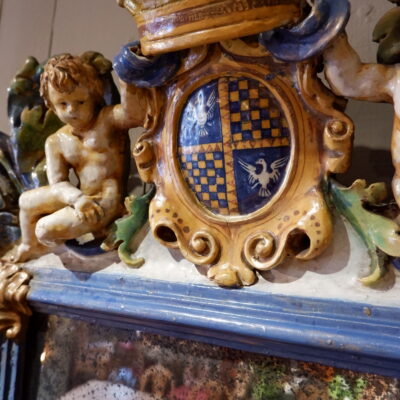 Grand miroir orné de Putti et d’une couronne sur blason- en faïence vernissée polychrome – Italie XIXe