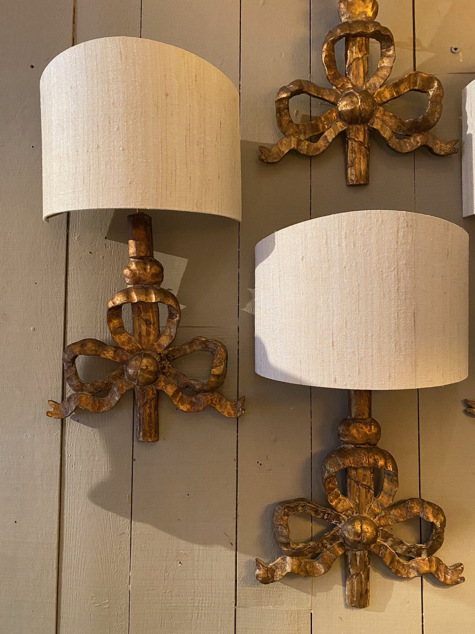 Une paire d’appliques “grands noeuds XVIIIe” en bois & sculpté & doré + A/j écrans en soie ivoire