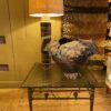 Table basse base en bronze motif liane de feuilles entrelacées et plateau en verre fumé grené - Ca1970