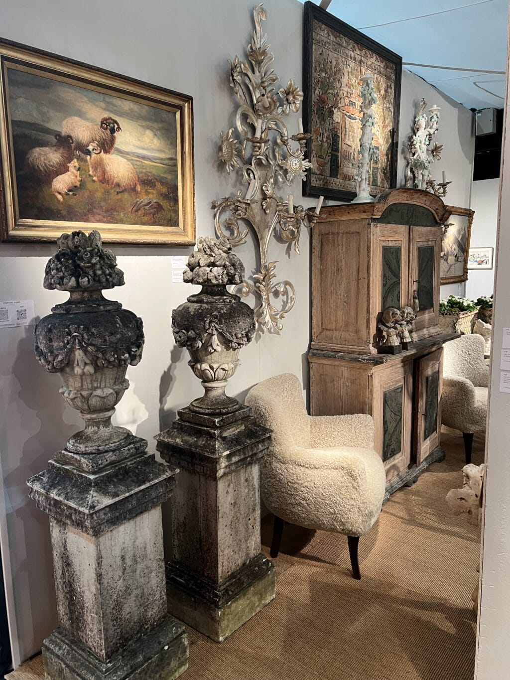 Paire de vases en pierre reconstituée ornés de guirlandes de fleurs et de fruits sur le dessus.