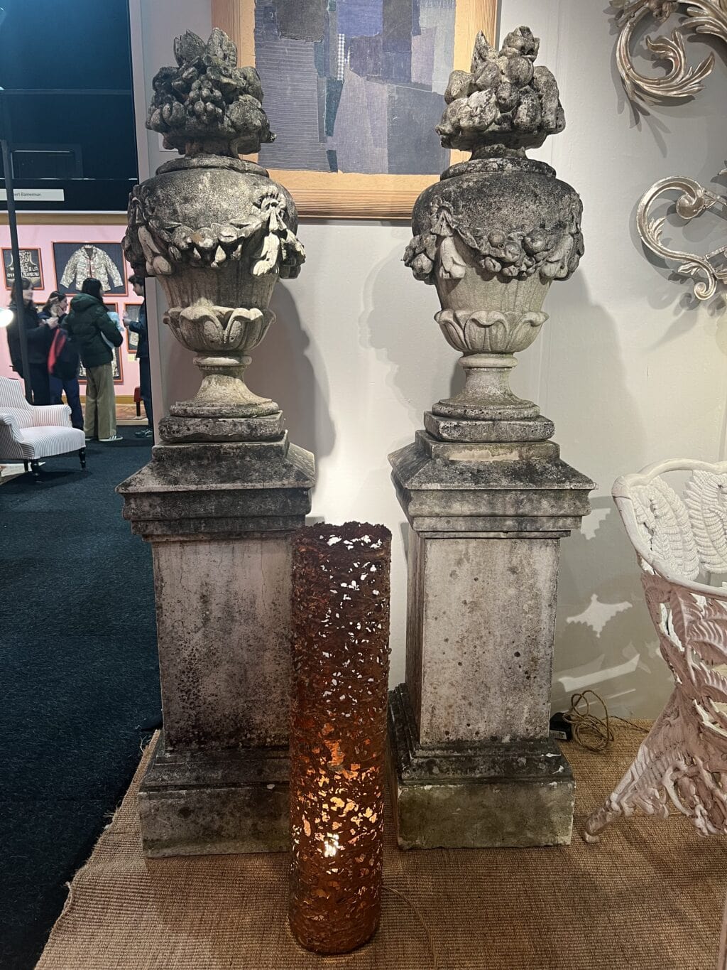 Paire de vases en pierre reconstituée ornés de guirlandes de fleurs et de fruits sur le dessus.