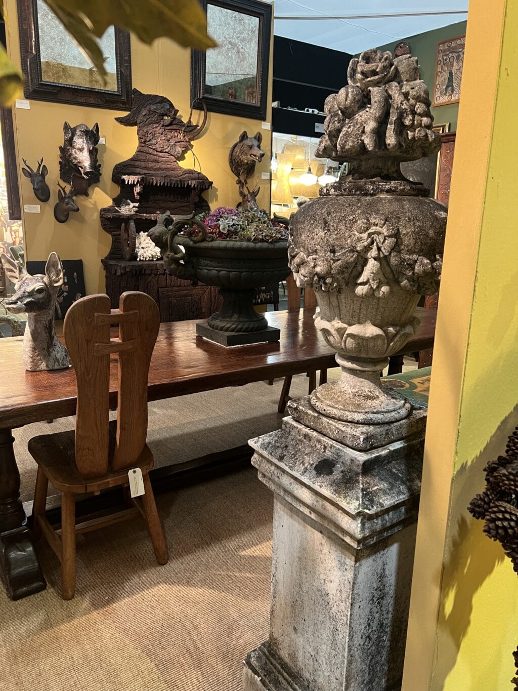 Paire de vases en pierre reconstituée ornés de guirlandes de fleurs et de fruits sur le dessus.