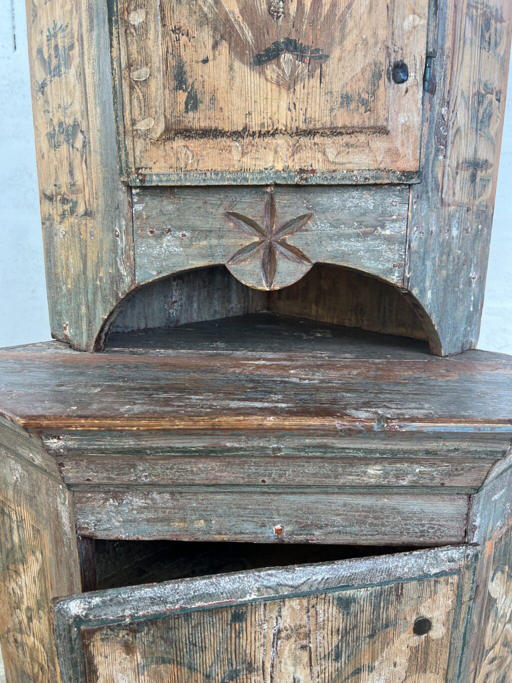 Encoignure suédoise ancienne à deux corps en sapin peint rechampi avec décor floral et niche sculptée