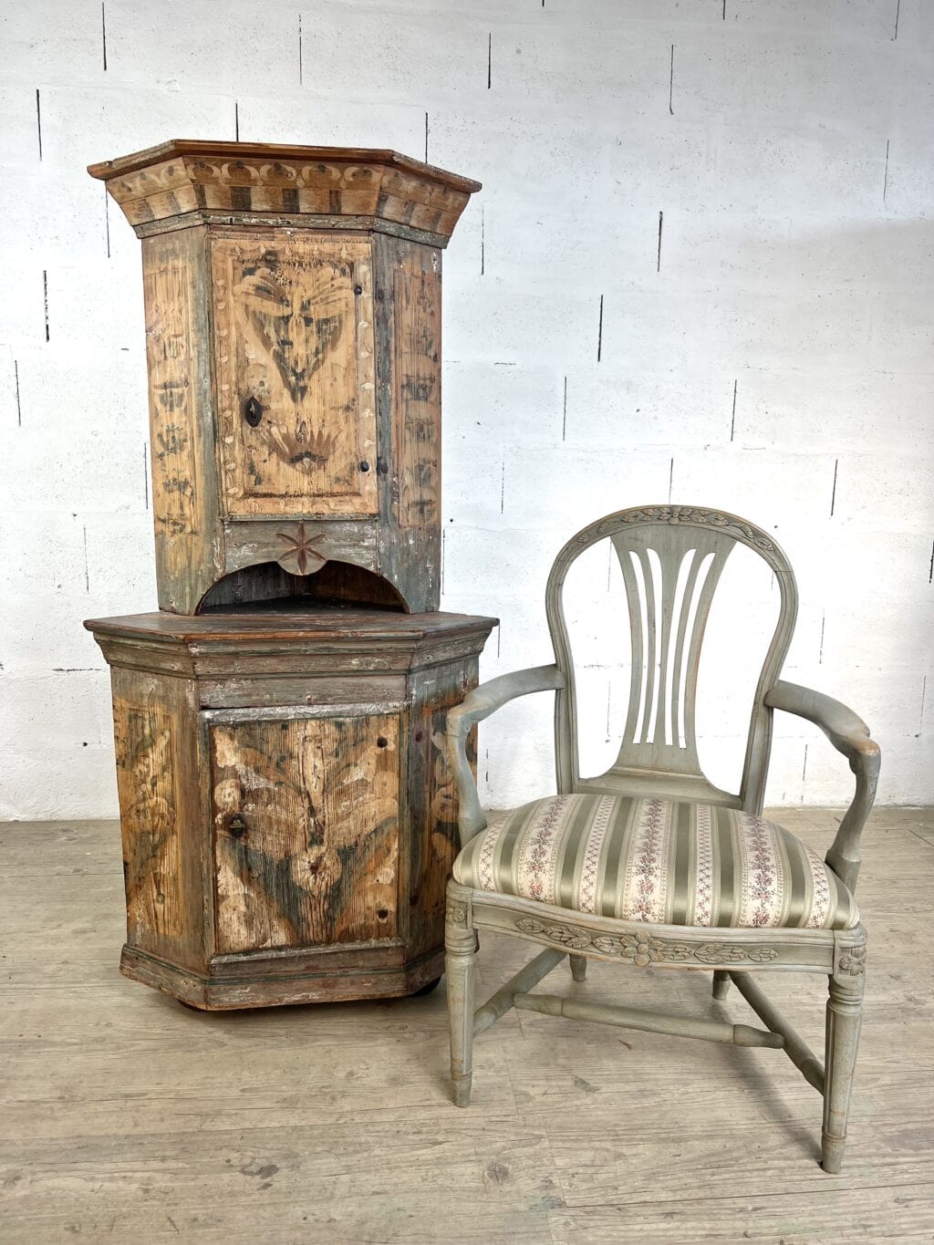 Encoignure suédoise ancienne à deux corps en sapin peint rechampi avec décor floral et niche sculptée