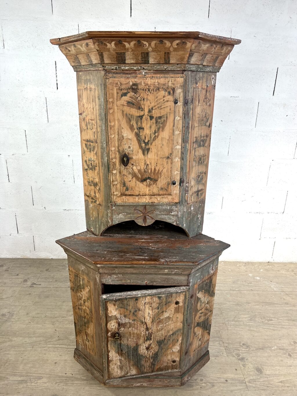 Encoignure suédoise ancienne à deux corps en sapin peint rechampi avec décor floral et niche sculptée