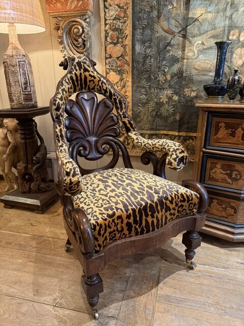 Fauteuil indo-anglais du XIXe siècle en bois teinté, dossier cintré en forme de palmette, sur roulettes.