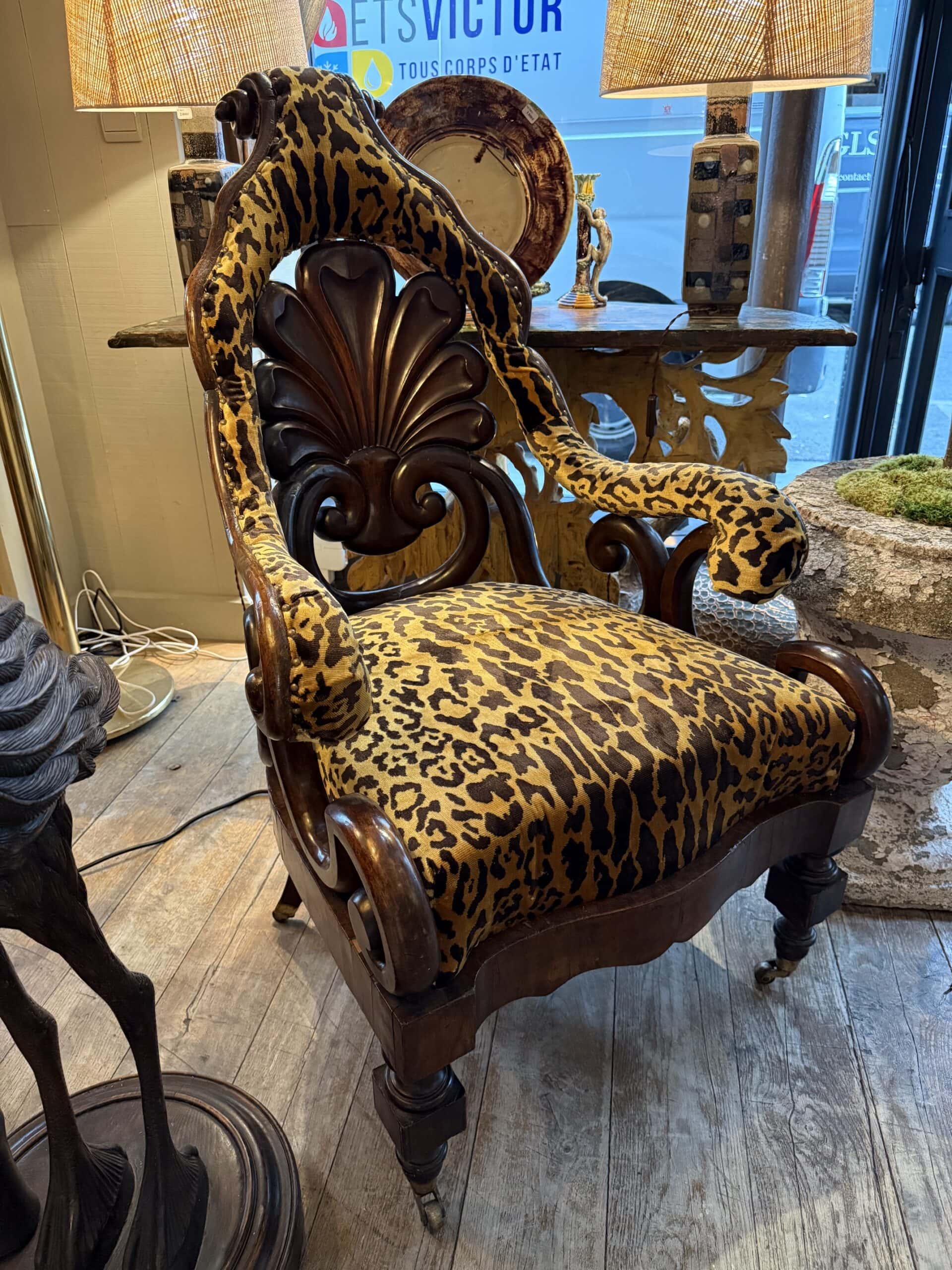 Fauteuil indo-anglais du XIXe siècle en bois teinté, dossier cintré en forme de palmette, sur roulettes.